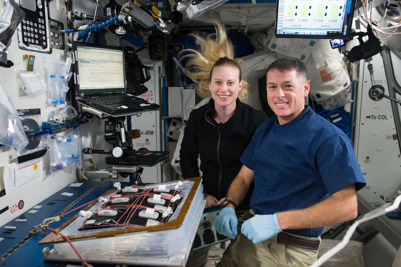 iss049e046023 (10/25/2016) --- NASA astronauts Shane and Kate Rubins are photographed during VEG-03 initiation in the Node 2 module. Organisms grow differently in space, from single-celled bacteria to plants and humans. But future long-duration space missions will require crew members to grow their own food, so understanding how plants respond to microgravity is an important step toward that goal. Veg-03 uses the Veggie plant growth facility to cultivate a type of cabbage, which is harvested in orbit with samples returned to Earth for testing.