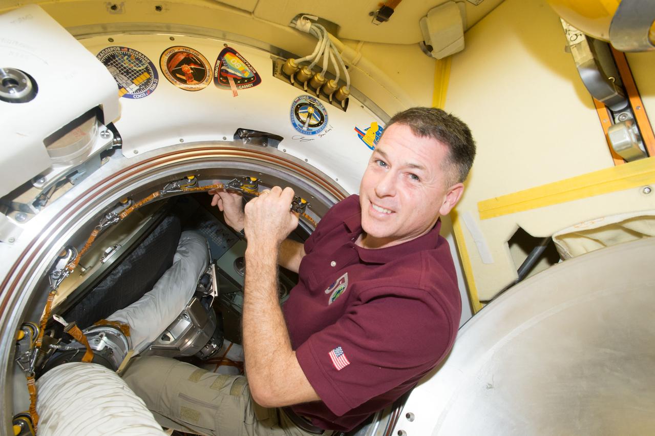 iss050e054575 (03/05/2017) --- NASA astronaut Shane Kimbrough signs a bulkhead on the Russian segment of the International Space station next to the crew patch for his Soyuz MS-03 spacecraft.