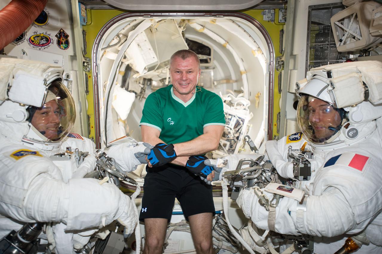 iss050e059576 (03/24/2017) --- Russian cosmonaut Oleg Novitskiy (middle) poses with Expedition 50 Commander Shane Kimbrough of NASA (left) and Flight Engineer Thomas Pesquet of ESA (European Space Agency) (right) prior to their spacewalk. The pair conducted a six hour and 34 minute spacewalk on March 24, 2017. The two astronauts successfully disconnected cables and electrical connections on the Pressurized Mating Adapter-3 to prepare for its robotic move, lubricated the latching end effector on the Special Purpose Dexterous Manipulator “extension” for the Canadarm2 robotic arm, inspected a radiator valve and replaced cameras on the Japanese segment of the outpost.