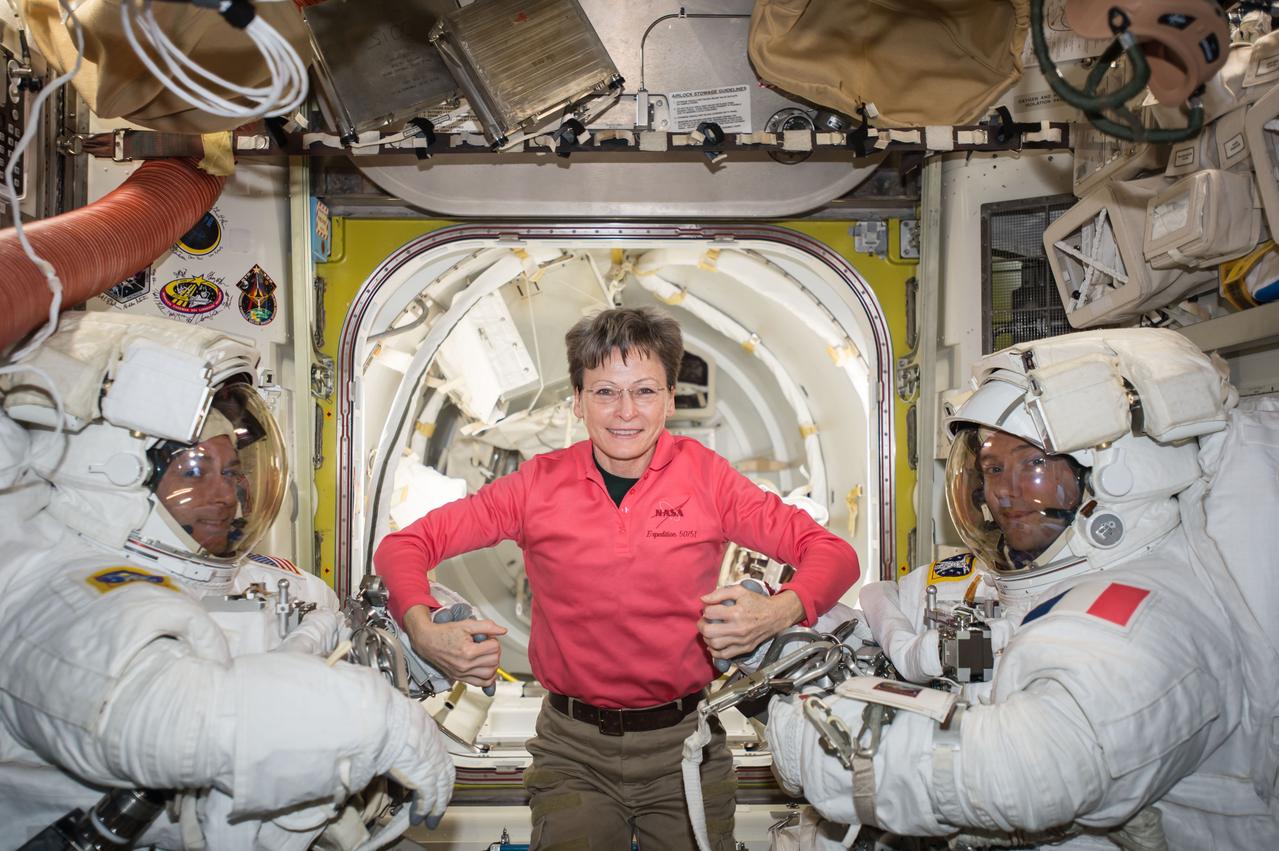 iss050e059579 (03/24/2017) --- NASA astronaut Peggy Whitson (middle) poses with Expedition 50 Commander Shane Kimbrough of NASA (left) and Flight Engineer Thomas Pesquet of ESA (European Space Agency) (right) prior to their spacewalk. The pair conducted a six hour and 34 minute spacewalk on March 24, 2017. The two astronauts successfully disconnected cables and electrical connections on the Pressurized Mating Adapter-3 to prepare for its robotic move, lubricated the latching end effector on the Special Purpose Dexterous Manipulator “extension” for the Canadarm2 robotic arm, inspected a radiator valve and replaced cameras on the Japanese segment of the outpost.