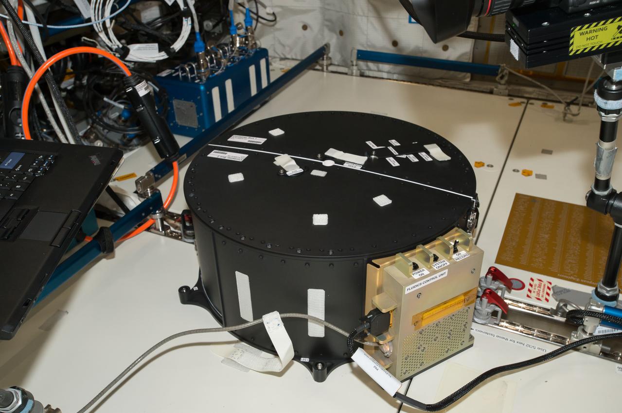 iss051e034001 (5/2/2017) --- Documentation of the Container Box attached to the COL1D1-D2 Seat Track during the first run of the Fluid Dynamics in Space (FLUIDICS) experiment. Image was taken in the Columbus European Laboratory. The FLUIDICS investigation evaluates the Center of Mass (CoM) position regarding a temperature gradient on a representation of a fuel tank. The observation of capillary wave turbulence on the surface of a fluid layer in a low-gravity environment can provide insights into measuring the existing volume in a sphere.