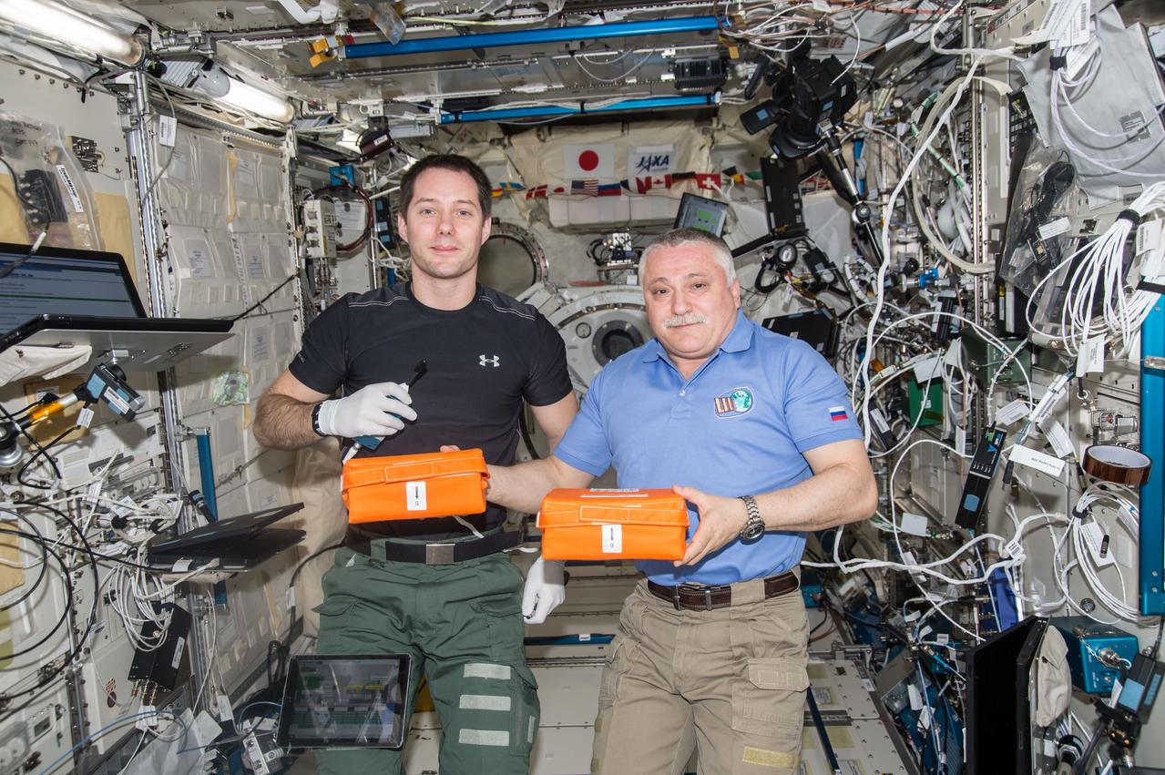 iss051e052377 96/2/2017) --- European Space Agency (ESA) astronaut Thomas Pesquet and cosmonaut Fyodor Yurchikhin pose with Canister Bags during handover of Canisters removed from the Protein Crystallization Research Facility (PCRF. The image was taken in the Kibo Japanese Experiment Pressurized Module (JPM) during Japan Aerospace Exploration Agency (JAXA) Protein Crystal Growth (PCG) and Kristallizator experiment operations (OPS).