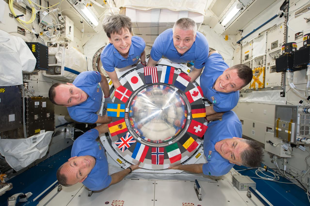 iss052e031832 (8/5/2017) --- Expedition 52 crew pose for their on-orbit crew portrait gathered around the Japanese Experiment Module (JEM) internal airlock aboard the International Space Station (ISS). Flags from all the International Partners are visible around the airlock hatch. From left to right: Astronaut Randy Bresnik, Cosmonaut Sergey Ryzanskiy, Astronaut Peggy Whitson, Cosmonaut Fyodor Yurchikhin, Astronaut Jack Fischer and European Space Agency (ESA) astronaut Paolo Nespoli.