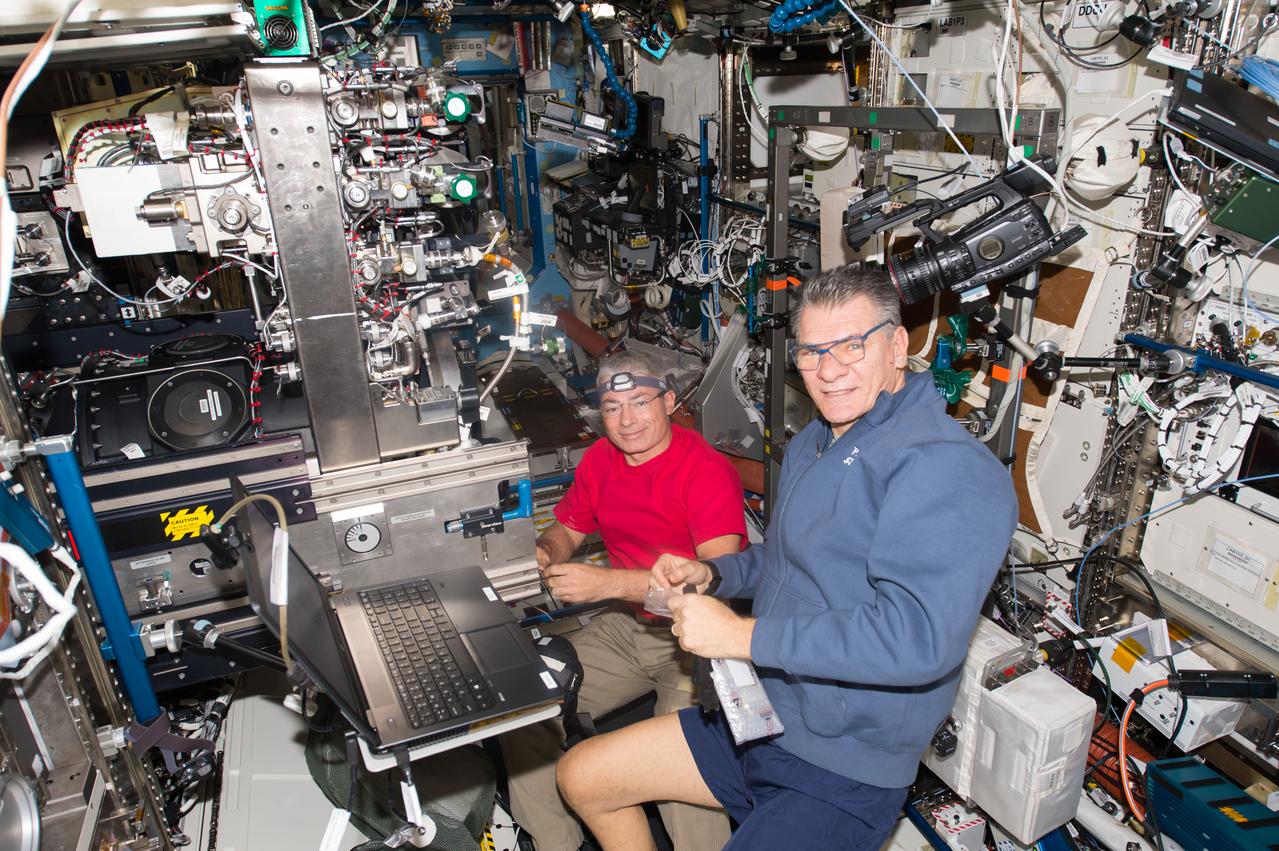 iss053e047442 (Sept. 25, 2017) --- Astronauts Mark Vande Hei (left) and Paolo Nespoli work on science gear inside the Destiny laboratory module.