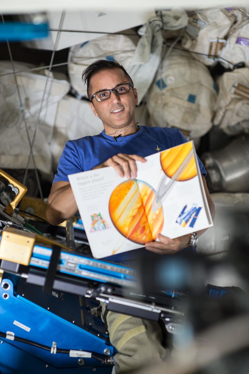 iss053e210425 (Nov. 7, 2017) --- Flight Engineer Joe Acaba holds a children's book that he is reading from as part of the Story Time From Space program. Astronauts read aloud from a STEM-related children's book while being videotaped and demonstrate simple science concepts and experiments aboard the International Space Station.