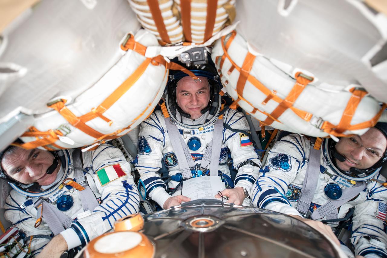 iss053e304918 (Dec. 4, 2017) --- Expedition 52-53 crew members (from left) Paolo Nespoli, Sergey Ryazanskiy and Randy Bresnik are pictured  inside the Soyuz MS-05 spacecraft wearing their Sokol launch and entry suits. The veteran space travelers were preparing for their return to Earth after 139 days in space and practicing the procedures they will use when they undock from the Rassvet module in their Soyuz vehicle and parachute to a landing in Kazakhstan Dec.14.
