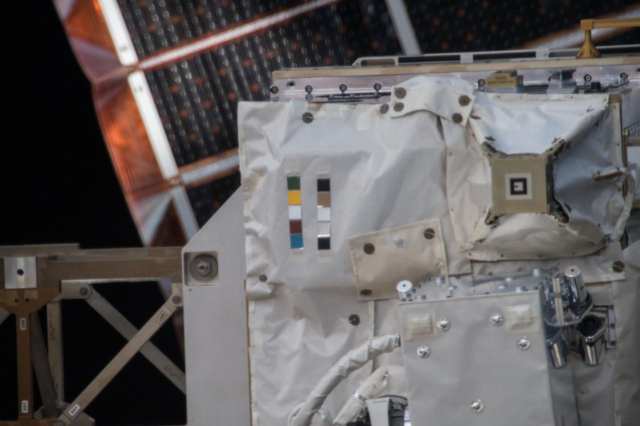 iss054e004111 (Dec. 26, 2017) --- Space Test Program - Houston 5 - Innovative Coatings Experiment (STP-H5-ICE) with International Space Station (ISS) solar panels in the background. A spacecraft’s exterior coating protects against extreme temperatures, shields the spacecraft from radiation, prevents contamination, and guides cameras that help robots or humans capture and service the spacecraft. STP-H5-ICE studies different paints and coatings that protext spacecraft exteriors.