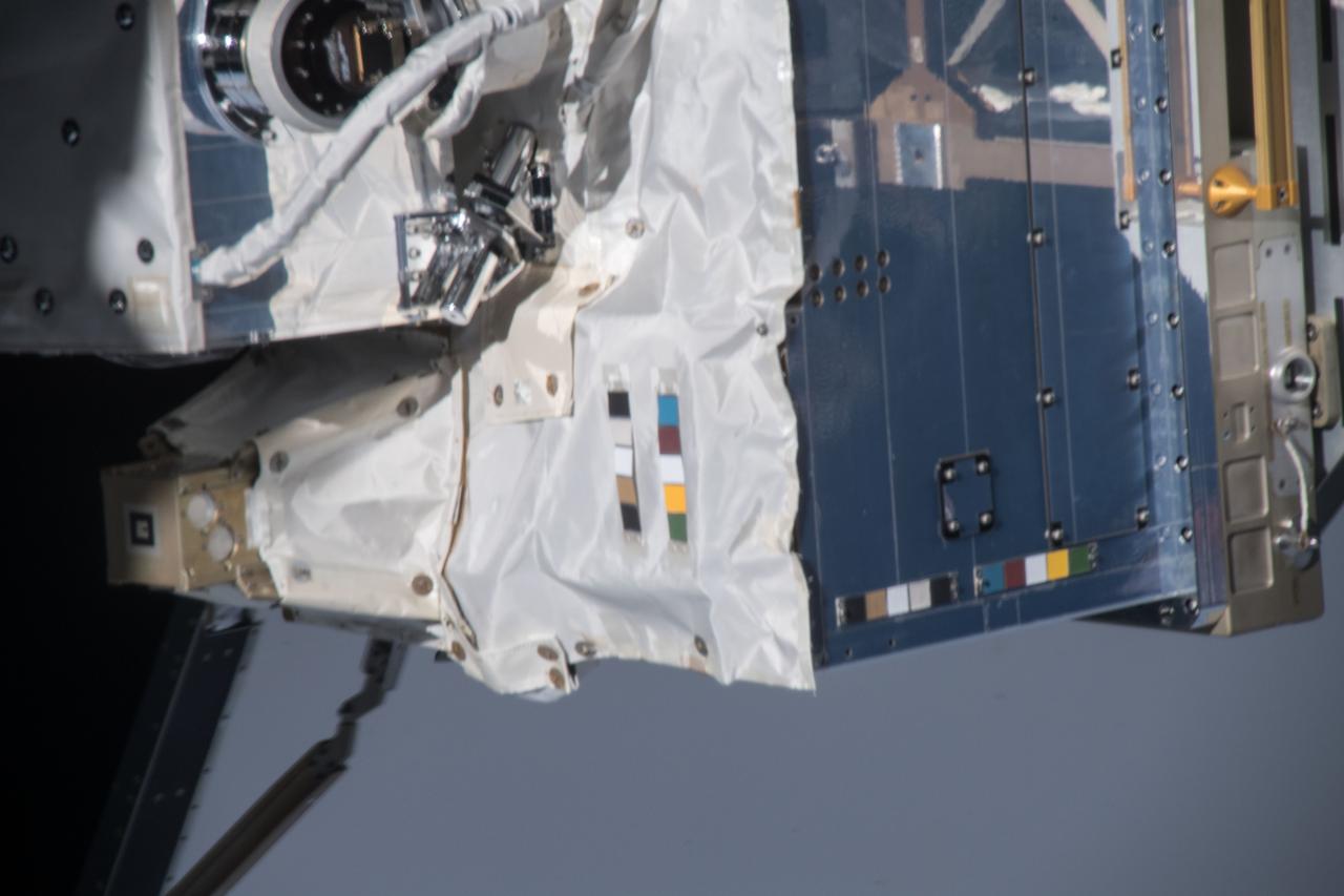 iss054e004119 (Dec. 26, 2017) --- Space Test Program - Houston 5 - Innovative Coatings Experiment (STP-H5-ICE) with International Space Station (ISS) radiator in the background. A spacecraft’s exterior coating protects against extreme temperatures, shields the spacecraft from radiation, prevents contamination, and guides cameras that help robots or humans capture and service the spacecraft. STP-H5-ICE studies different paints and coatings that protect spacecraft exteriors.