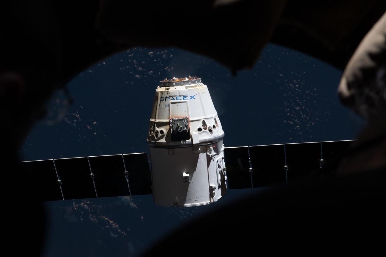 iss054e022063 (Jan. 13, 2018) ---The SpaceX Dragon is pictured from inside the seven-windowed cupola moments after ground controllers remotely commanded the Canadarm2 to release it from its grips.