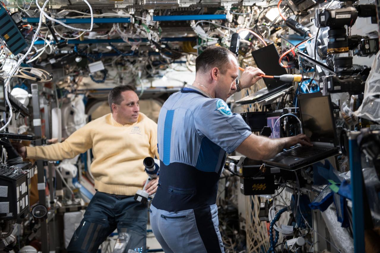iss054e022392 (Jan. 19, 2018) --- Cosmonauts Anton Shkaplerov (left) and Alexander Misurkin work inside the U.S. Destiny laboratory module participating in eye exams using a fundoscope.