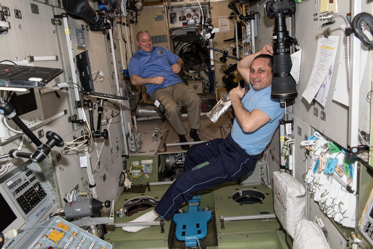 iss055e004815 (March 23, 2018) --- NASA astronaut Scott Tingle (background left) and Commander Anton Shkaplerov relax inside the Zvezda service module moments before the arrival of three new Expedition 55 crew members on March 23, 2018. The Soyuz MS-08 spacecraft carrying Soyuz Commander Oleg Artemyev and Flight Engineers Drew Feustel and Ricky Arnold would dock to the Poisk docking compartment on March 23, 2018 at 3:40 p.m. EDT.