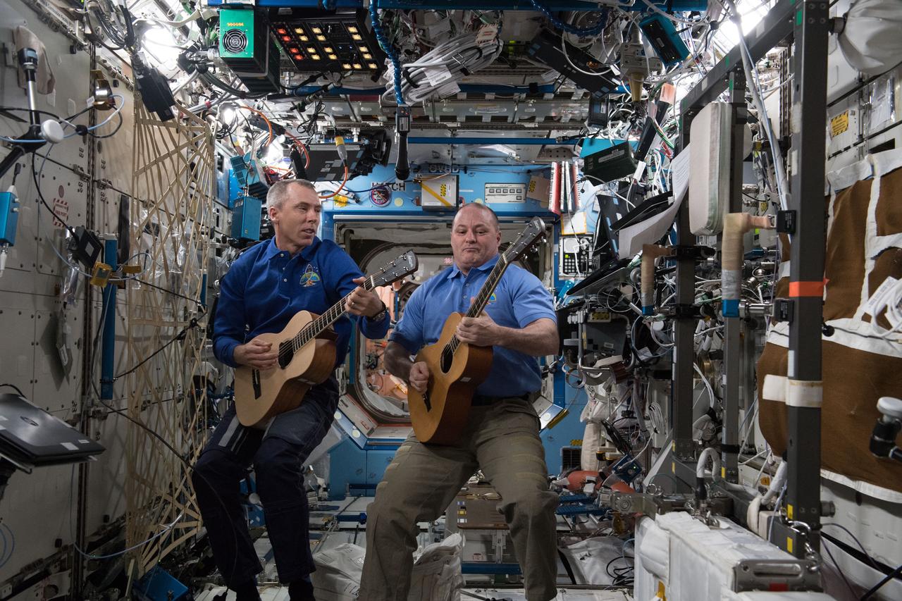 iss055e035378 (April 27, 2018) --- NASA astronauts Drew Feustel (left) and Scott Tingle play guitar inside the Destiny laboratory module during an educational event with school districts in Aransas Pass, Texas.