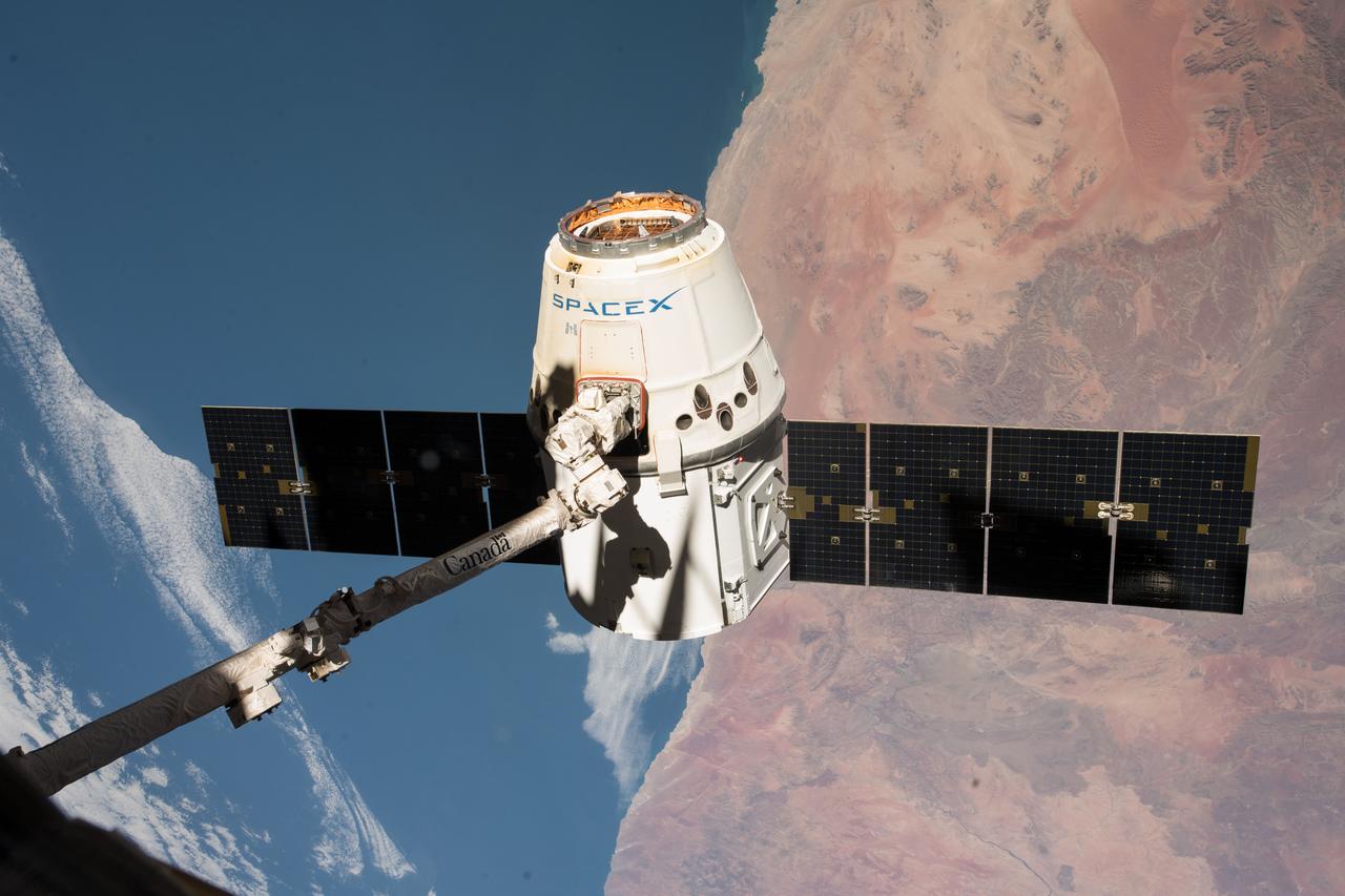 iss055e057155 (May 5, 2018) --- The SpaceX Dragon cargo craft is pictured in the grips of the Canadarm2 robotic arm as the International Space Station was orbiting across the central coast of Namibia. Dragon was later released for its splashdown in the Pacific Ocean off the coast of California on May 5, 2018 ending the SpaceX CRS-14 mission.