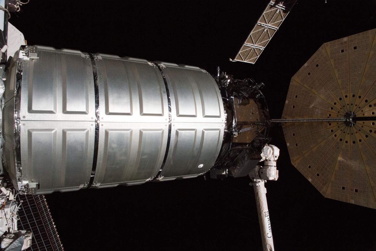 iss055e109714 (May 24, 2018) --- The Northrop Grumman (formerly Orbital ATK) Cygnus resupply ship with its round, brass-colored UltraFlex solar arrays is guided to its port on the Unity module shortly after it was captured with the Canadarm2 robotic arm.