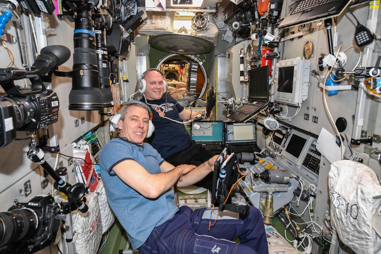 iss056e025296 (June 20, 2018) --- Expedition 55-56 crewmates Drew Feustel (foreground) and Oleg Artemyev and are gathered in the Zvzeda service module practicing the evacuation of the International Space Station in the unlikely event an emergency would require the crew to enter their Soyuz spacecraft and return to Earth.