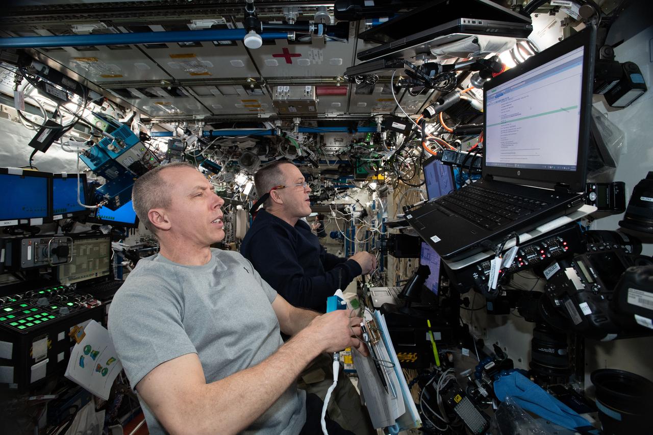 iss056e037503 (June 26, 2018) --- NASA astronauts Drew Feustel (foreground) and Ricky Arnold practice on a computer before their upcoming robotic maneuvers to capture the SpaceX Dragon cargo craft upon its arrival at the International Space Station on July 2, 2018.