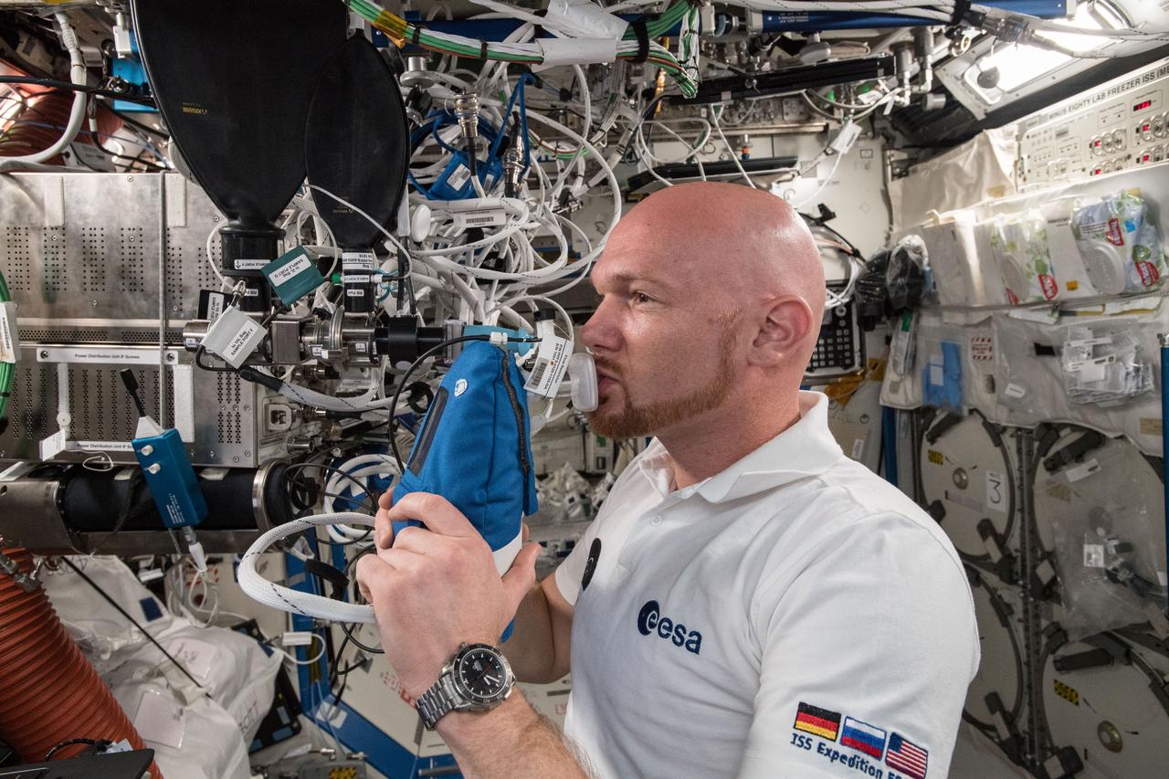 iss056e055604 (June 29, 2018) --- Astronaut Alexander Gerst of ESA (European Space Agency) exhales into an ultra-sensitive gas analyzer for the Airway Monitoring experiment. The experiment studies the occurrence and indicators of airway inflammation in crew members to help flight surgeons plan safer, long-term missions to the Moon, Mars and beyond. Results may also help doctors treat patients on Earth with asthma or other airway inflammatory diseases.