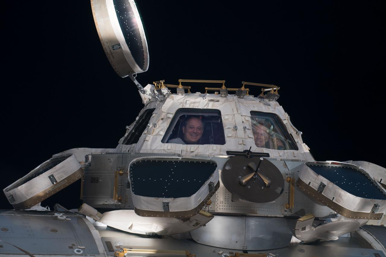 iss056e062934 (June 30, 2018) --- (From left) Flight Engineer Ricky Arnold and Commander Drew Feustel, both NASA astronauts, peer out from windows inside the Cupola, also known as the International Space Station's "window to the world."