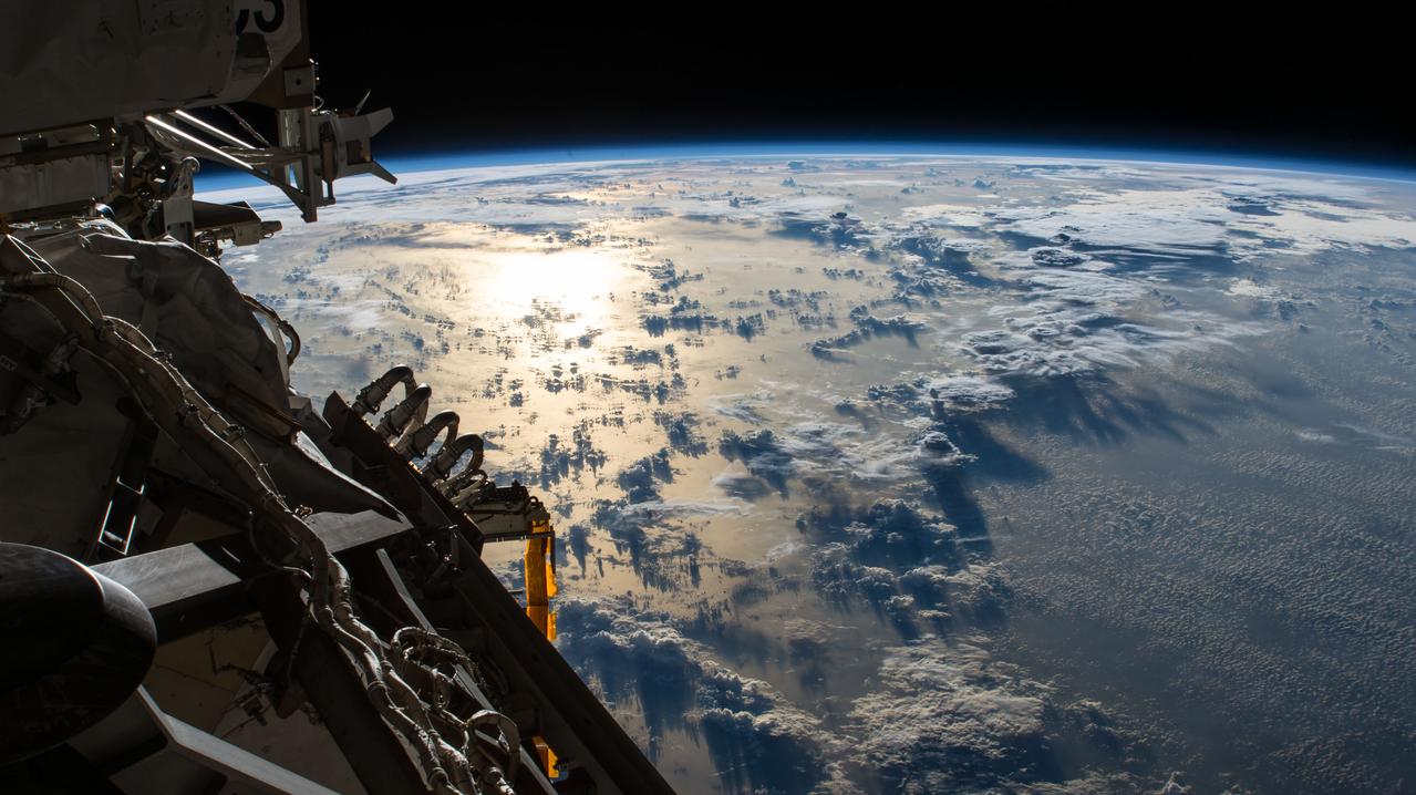 iss056e097560 (July 20, 2018) --- The Sun's glint reflects off the Pacific Ocean shadowed by a line of cumulonimbus clouds as the International Space Station orbited over the International Date Line about 253 miles above the Earth's surface.
