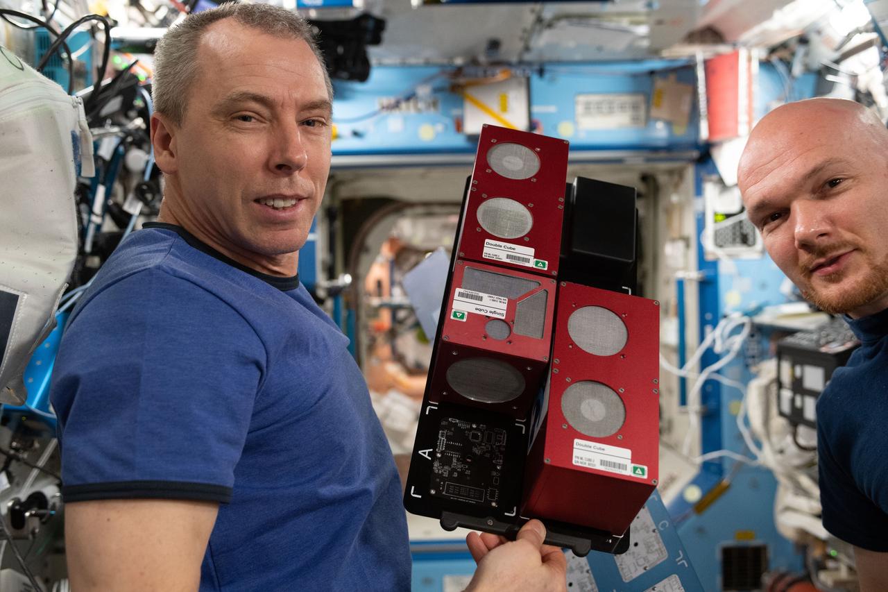 iss056e101065 (Aug. 1, 2018) --- Expedition 56 Commander Drew Feustel displays TangoLab hardware as Flight Engineer Alexander Gerst looks on. The TangoLab facilities house experimental modules called CubeLabs that enable research into plant biology, microbiology, cell culture, tissue culture, and flow chemistry.