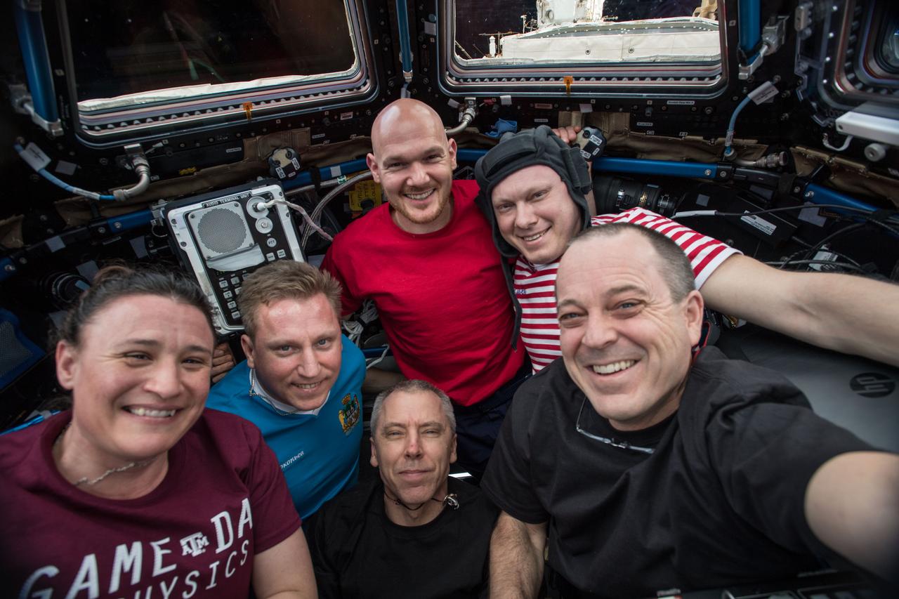 iss056e151195 (Aug. 19, 2018) --- The entire six-member Expedition 56 crew gathers in the Cupola, the International Space Station's "window to the world," for a team portrait. In the front row, from left, are NASA astronauts Serena Auñon-Chancellor, Commander Drew Fuestel and Ricky Arnold. Behind them, from left, are Roscosmos cosmonauts Sergey Prokopyev and Oleg Artemyev. At the top of the group is astronaut Alexander Gerst of ESA (European Space Agency).