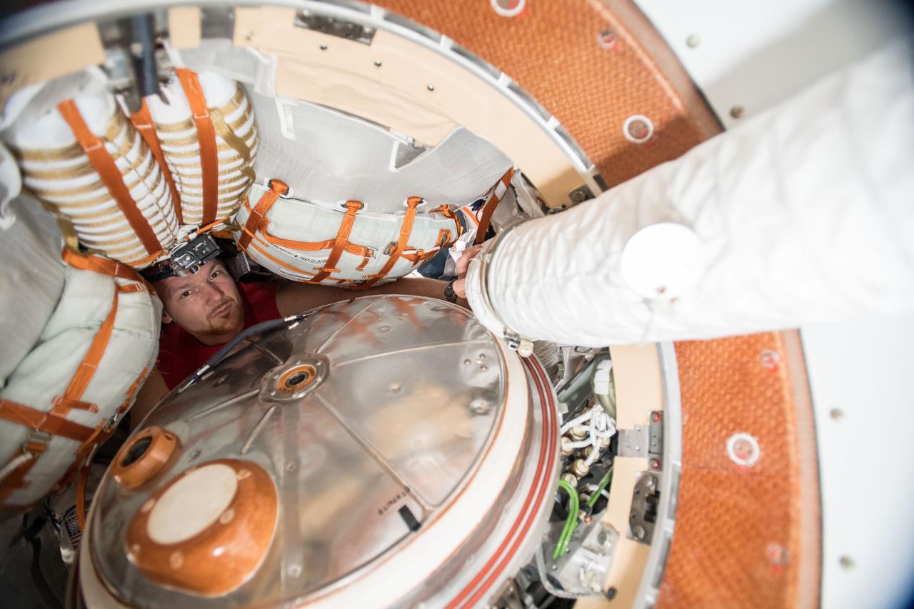 iss057e023088 (Oct. 10, 2018) --- Expedition 57 Commander Alexander Gerst from ESA (European Space Agency) looks out from inside the Soyuz MS-09 spacecraft docked to the Rassvet module seemingly dwarfed by cargo bags and the Soyuz hatch.