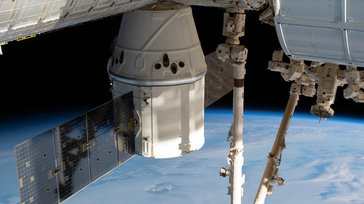 iss058e002241 (Jan. 7, 2019) --- The SpaceX Dragon cargo craft is pictured attached to the International Space Station's Harmony module as the orbital complex orbited 261 miles above the Indian Ocean southeast of the continent of Africa. The Canadarm2 robotic arm vertically splits the frame prior to grappling the spacecraft ahead of planned departure activities.
