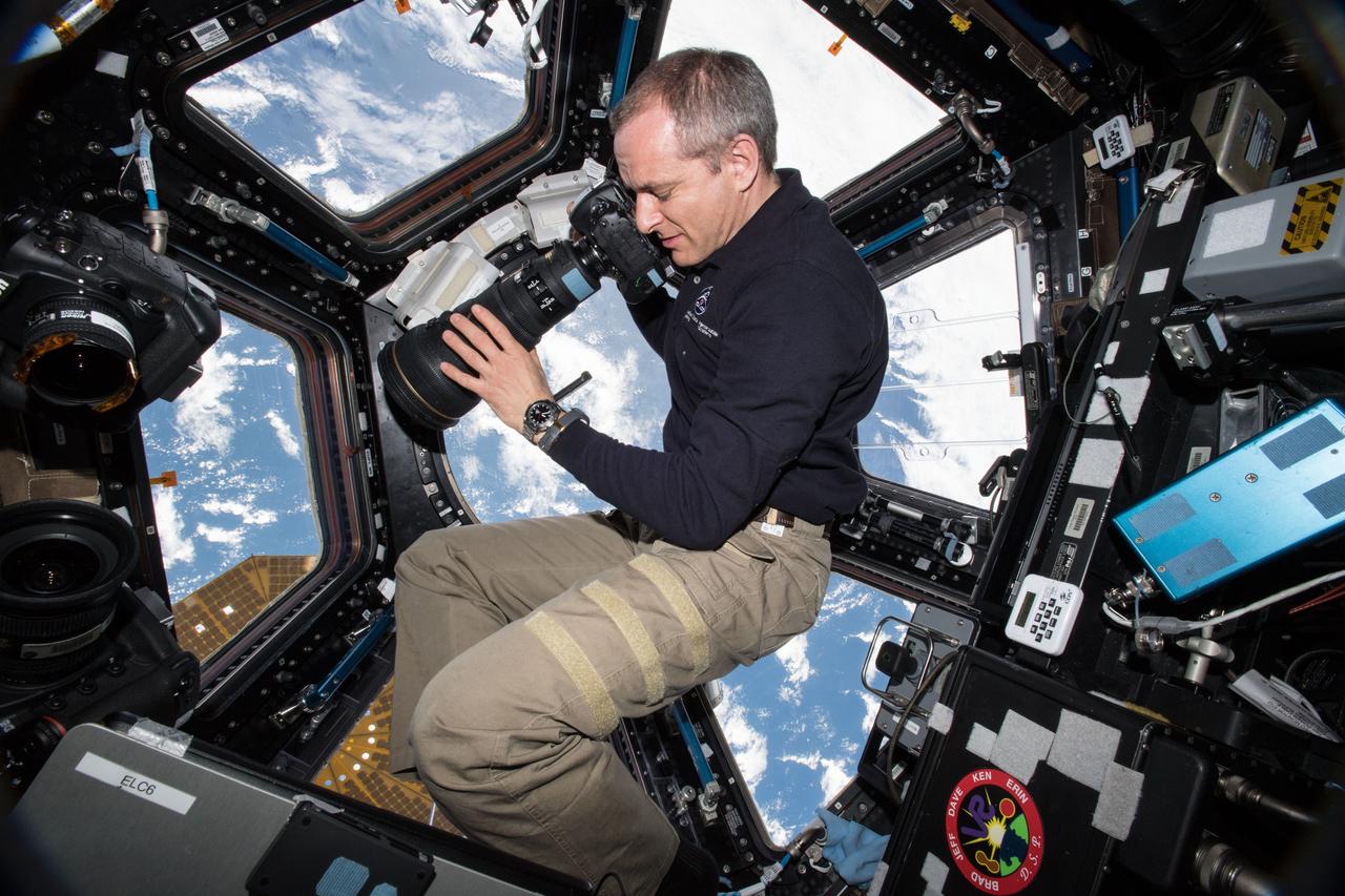iss058e003901 (Jan. 15, 2019) --- Astronaut David Saint-Jacques of the Canadian Space Agency takes pictures of the Earth below from inside the International Space Station's "window to the world," the seven-windowed cupola.