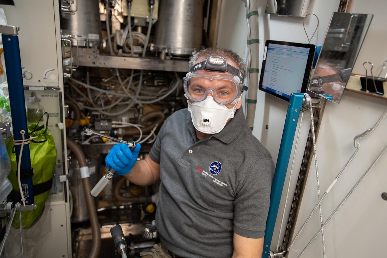 iss058e004176 (Jan. 16, 2019) --- Astronaut David Saint-Jacques of the Canadian Space Agency performs orbital plumbing work as he removes and replaces hydraulic components in the Waste and Hygiene Compartment, also known as the International Space Station's toilet located in the Tranquility module.
