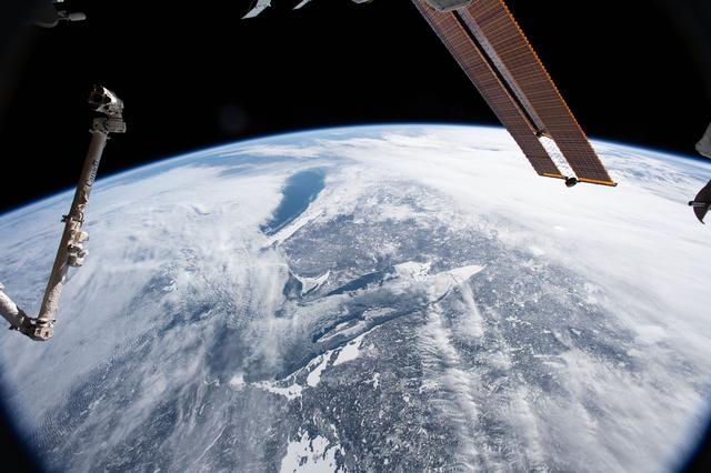 NASA image: Lake Superior and Lake Michigan surrounded by the cloudy and frozen terrain of the North American continent.