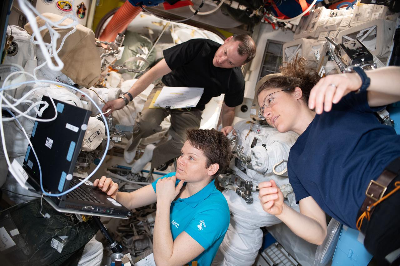iss059e000418 (March 16, 2019) --- NASA astronauts Nick Hague, Anne McClain and Christina Koch (right) work on U.S. spacesuit maintenance in the Quest airlock of the International Space Station.