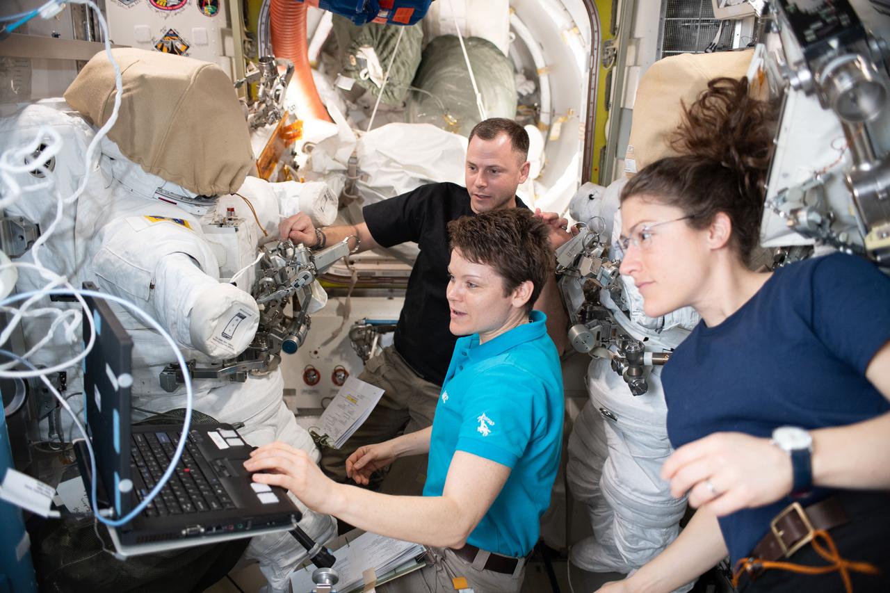 iss059e000427 (March 16, 2019) --- NASA astronauts Nick Hague, Anne McClain and Christina Koch (right) work on U.S. spacesuit maintenance in the Quest airlock of the International Space Station.