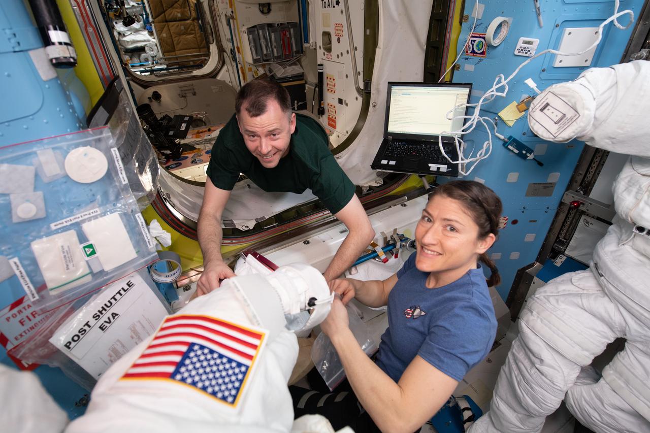 iss059e001037 (March 18, 2019) --- NASA astronauts Nick Hague (left) and Christina Koch work on U.S. spacesuits in the Quest airlock before the Expedition 59 crew members would begin a series of spacewalks to upgrade power systems on the International Space Station. Quest is divided into two parts. The equipment lock is where spacewalkers configure their tools and suit up in their U.S. spacesuits. The crew lock is the unit that is depressurized and repressurized and contains the hatch where the spacewalkers exit into the vacuum of space.