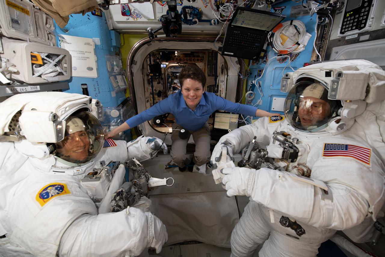 iss059e001093 (March 18, 2019) --- NASA astronaut Anne McClain assists fellow NASA astronauts Christina Koch (left) and Nick Hague as they verify their U.S. spacesuits are sized correctly and fit properly ahead of a set of upcoming spacewalks.