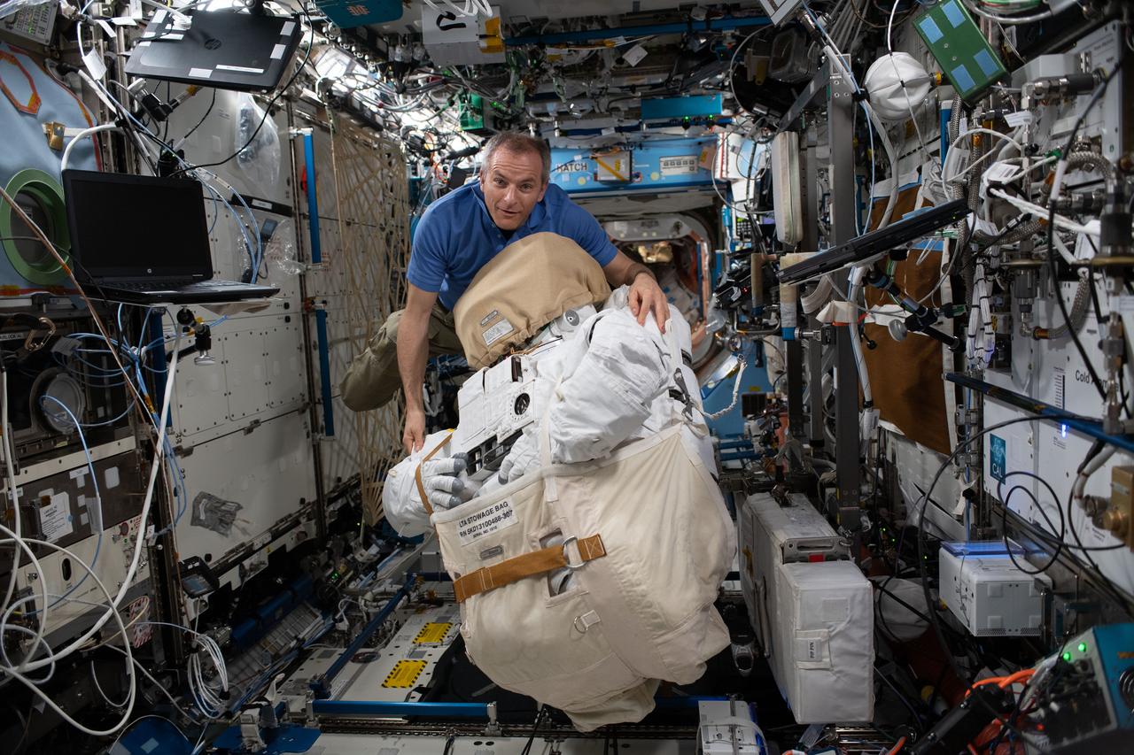 iss059e001272 (March 19, 2019) --- Canadian Space Agency astronaut David Saint-Jacques moves a U.S spacesuit inside the Destiny laboratory module.