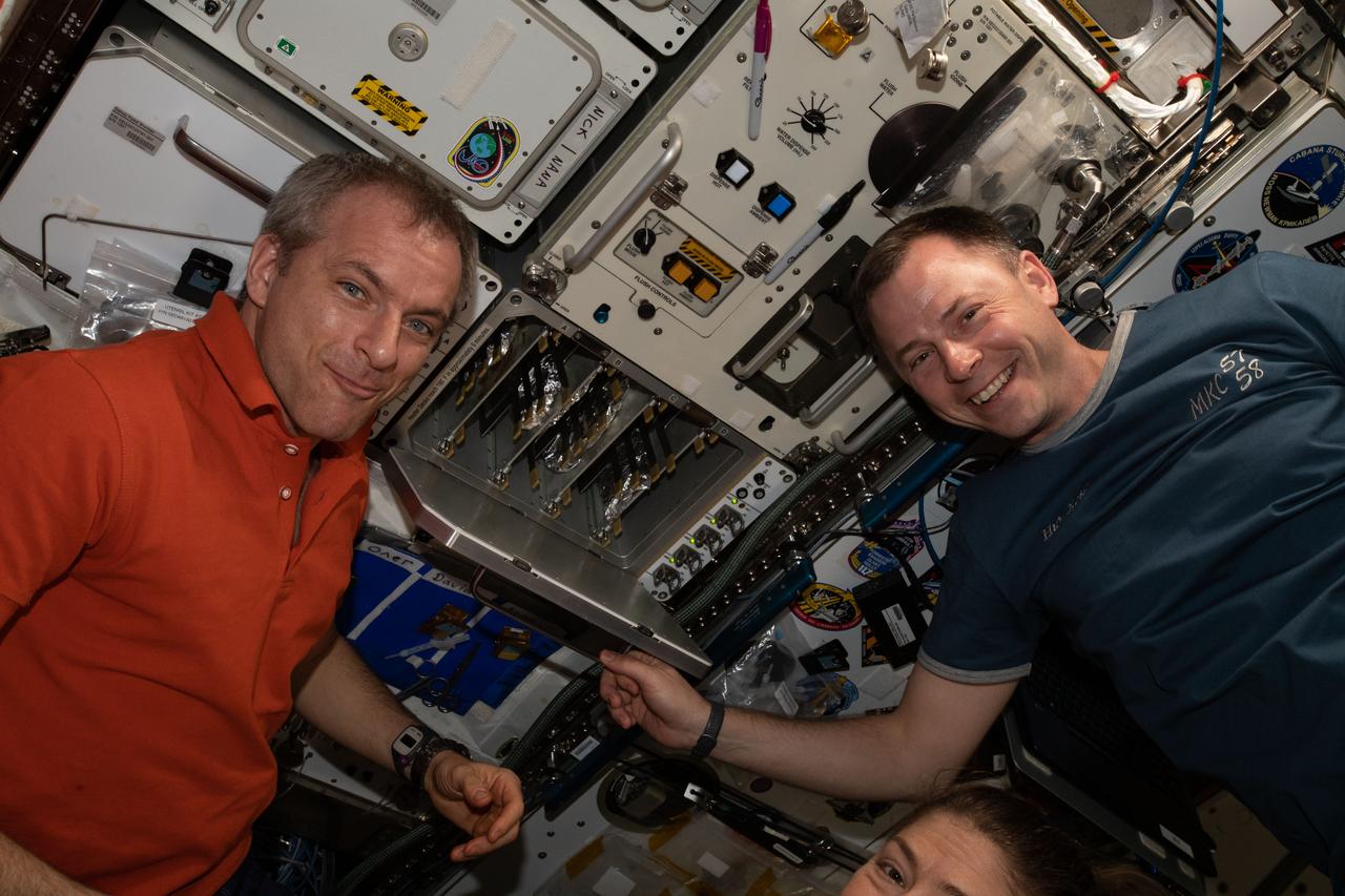 iss059e006481 (March 31, 2019) --- Astronauts David Saint-Jacques and Nick Hague eagerly await pizzas being cooked aboard the International Space Station's galley.