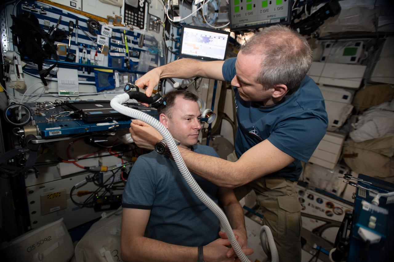 iss059e013110 (April 4, 2019) --- The orbital lab becomes a high-flying hair salon as David Saint-Jacques of the Canadian Space Agency trims NASA astronaut Nick Hague’s hair aboard the International Space Station.