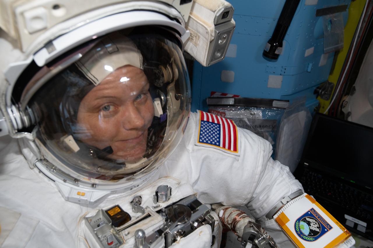 iss059e013388 (April 8, 2019) --- NASA astronaut Anne McClain is suited up in the U.S. Quest airlock preparing to begin what would be a six-and-a-half hour spacewalk with astronaut David Saint-Jacques (out of frame) of the Canadian Space Agency. The two spacewalkers established a redundant path of power to the Canadian-built robotic arm, known as Canadarm2, and installed cables to provide for more expansive wireless communications.