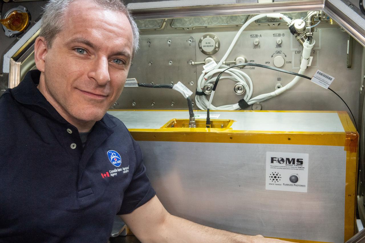 iss059e034721 (4/23/2019) --- Canadian Space Agency (CSA) astronaut David Saint-Jacques is photographed in front of the Microgravity Science Glovebox (MSG) during the installation of the Space Fibers experiment hardware into the MSG work volume. Manufacturing Fiber Optic Cable in Microgravity (Space Fibers) evaluates a method for producing fiber optic cable from a blend of zirconium, barium, lanthanum, sodium and aluminum, called ZBLAN, in space. ZBLAN produces glass one hundred times more transparent than silica-based glass, exceptional for fiber optics. Microgravity suppresses two mechanisms that commonly degrade fiber, and previous studies showed improved properties in fiber drawn in microgravity compared to that fabricated on the ground.