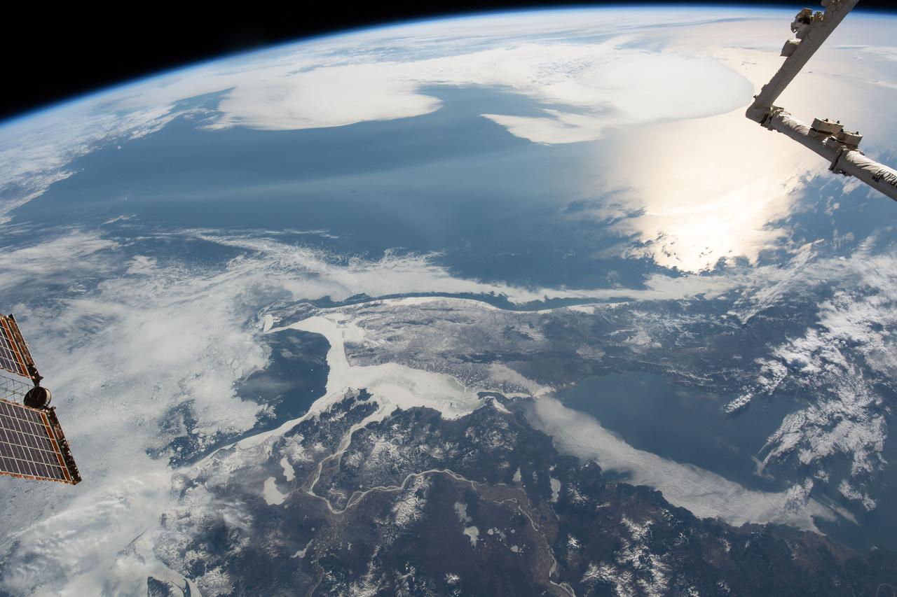 iss059e036722 (April 28, 2019) --- The International Space station was flying 258 miles above of China's eastern border with Russia when an Expedition 59 crewmember photographed the frozen Strait of Tartary. The strait separates the Russian island of Sakhalin from the Asian continent. The sun's glint beams off the Northern Pacific coast of Sakhalin.