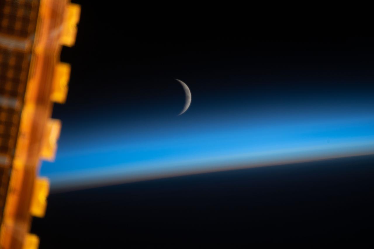 iss059e059210 (May 8, 2019) --- The waxing crescent moon is photographed just above Earth's limb and the bluish hue of the atmosphere at the beginning of an orbital sunrise. A portion of one of the International Space Station's solar arrays is seen in the left foreground as the orbital complex flew 258 miles above the Sea of Japan.