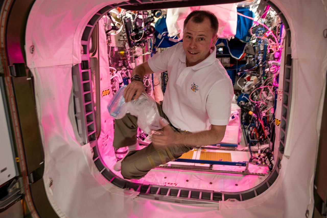 iss059e078446 (May 28, 2019) --- NASA astronaut Nick Hague floats inside the vestibule that connects the European Space Agency's Columbus laboratory module with NASA's Harmony module.
