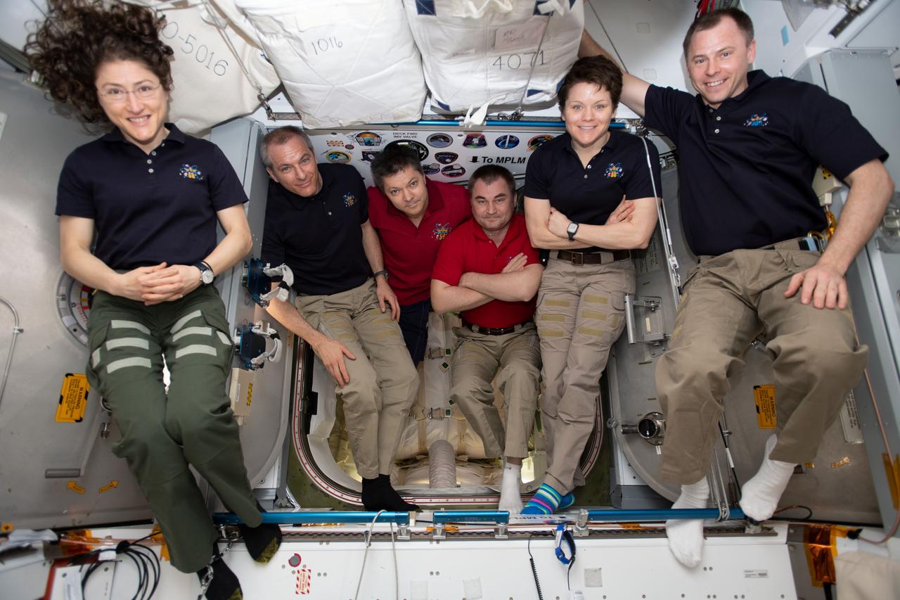 iss059e087883 (June 3, 2019) --- The six-member Expedition 59 crew gathers for a portrait inside of the vestibule between the SpaceX Dragon cargo craft and the Harmony module. The hatch to Dragon was later closed and the resupply ship detached from Harmony before it was released from the grips of the Canadarm2 robotic arm. Dragon spent nearly a month attached to the International Space Station. From left are, astronauts Christina Koch of NASA and David Saint-Jacques of the Canadian Space Agency; Commander Oleg Kononenko and Flight Engineer Alexey Ovchinin of Roscosmos; and NASA astronauts Anne McClain and Nick Hague.