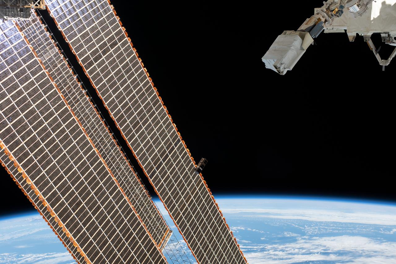 iss059e104368 (June 17, 2019) --- A tiny satellite from Singapore, also known as a CubeSat, is ejected from the Japanese Small Satellite Orbital Deployer past the International Space Station's solar arrays. The CubeSat was among three others from Asian nations deployed earlier for technology demonstrations in Earth orbit. The orbital complex was 254 miles above the Atlantic Ocean northeast of Venezuela when an Expedition 59 crewmember took this photograph.