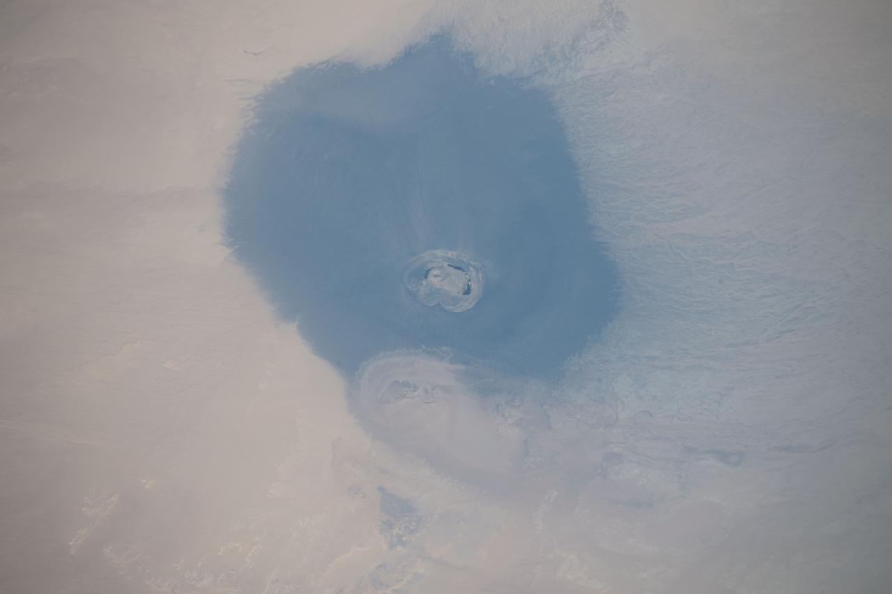 iss059e119235 (June 20, 2019) --- The International Space Station was orbiting 256 miles above the north African country of Libya when an Expedition 59 crewmember photographed the isolated volcanic crater of Waw an Namus, which is composed of dark ash and features three small saltwater lakes.
