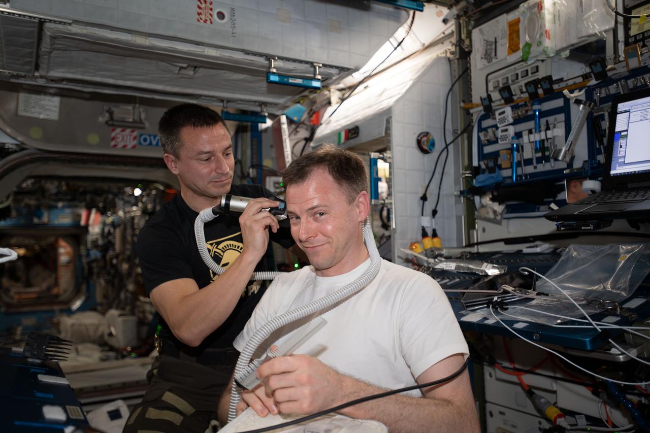 iss060e021661 (Aug. 3, 2019) --- International Space Station barber and Expedition 60 Flight Engineer Andrew Morgan of NASA trims the hair of fellow NASA astronaut Nick Hague.
