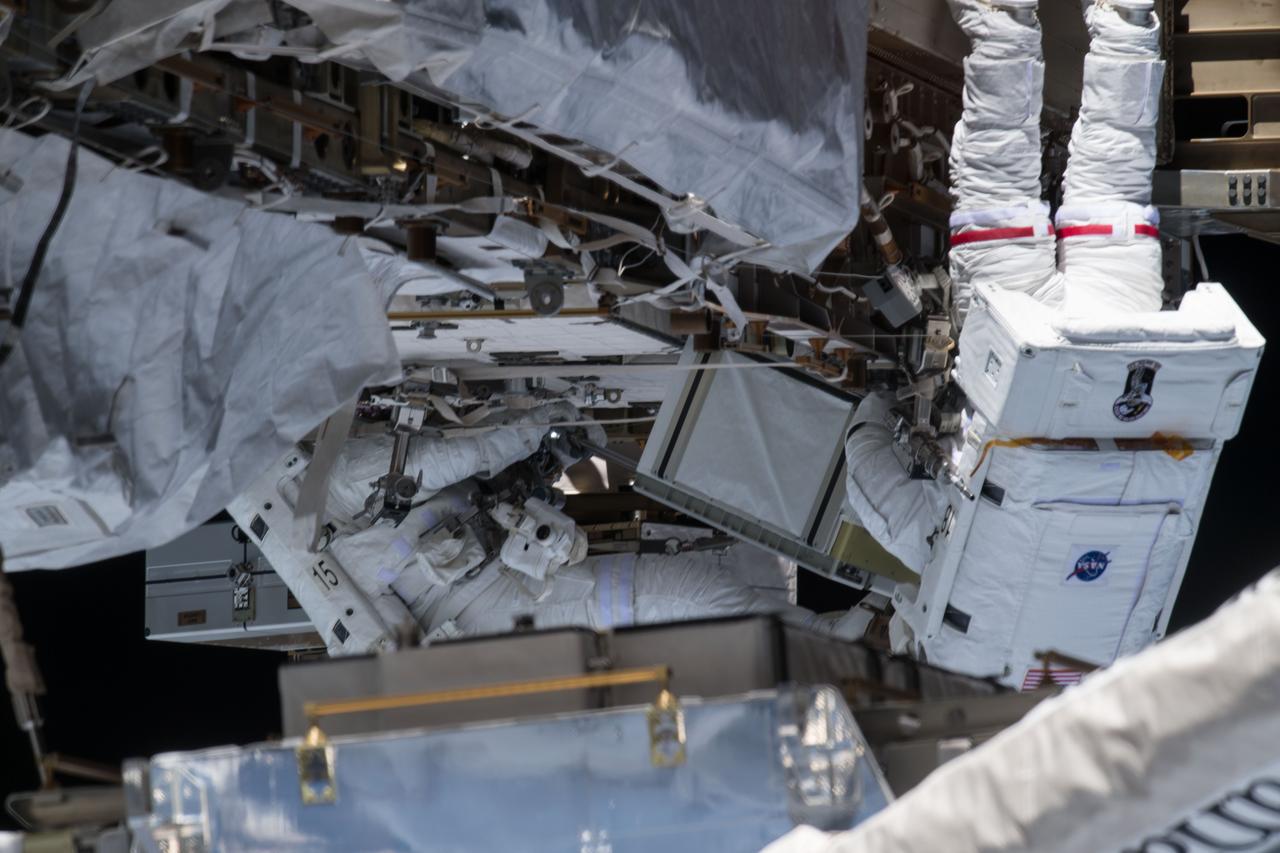iss061e001727 (Oct. 6, 2019) --- NASA astronaut Christina Koch (right) conducts a spacewalk at the Port-6 (P6) truss structure work site to upgrade International Space Station power systems. She and fellow NASA astronaut Andrew Morgan (left) worked outside in the vacuum of space for seven hours and one minute to begin the latest round of upgrading the station's large nickel-hydrogen batteries with newer, more powerful lithium-ion batteries.