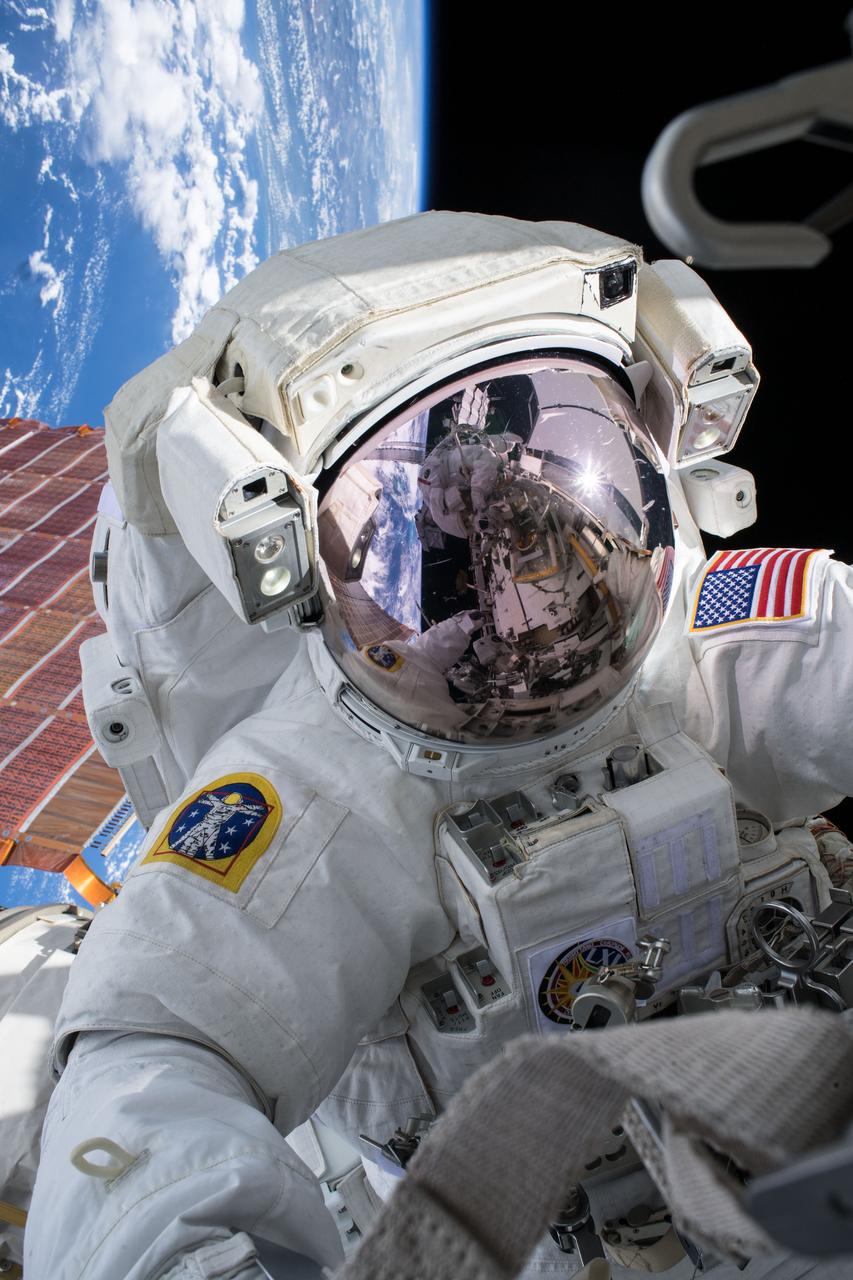 iss061e003293 (Oct. 6, 2019) --- NASA astronaut Andrew Morgan conducts a spacewalk at the Port- 6 (P6) truss structure work site to upgrade International Space Station power systems. He was photographed by fellow NASA astronaut Christina Koch as they worked outside in the vacuum of space for seven hours and one minute to begin the latest round of upgrading the station's large nickel-hydrogen batteries with newer, more powerful lithium-ion batteries.