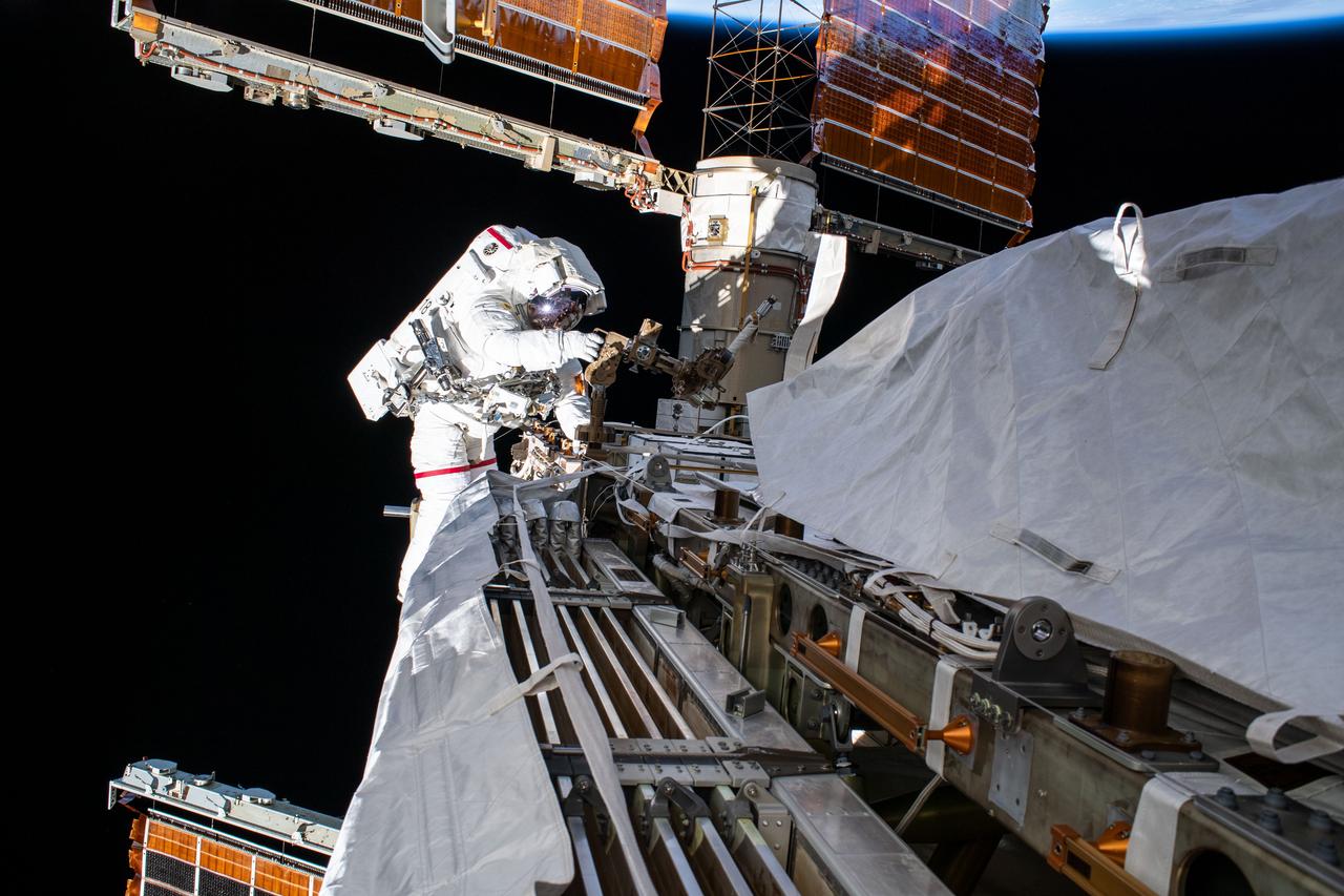 iss061e005535 (Oct. 11, 2019) --- NASA astronaut Andrew Morgan works while tethered on the Port 6 truss segment of the International Space Station to replace older hydrogen-nickel batteries with newer, more powerful lithium-ion batteries. The batteries store and distribute power collected from the station's basketball court-sized solar arrays directly behind Morgan.