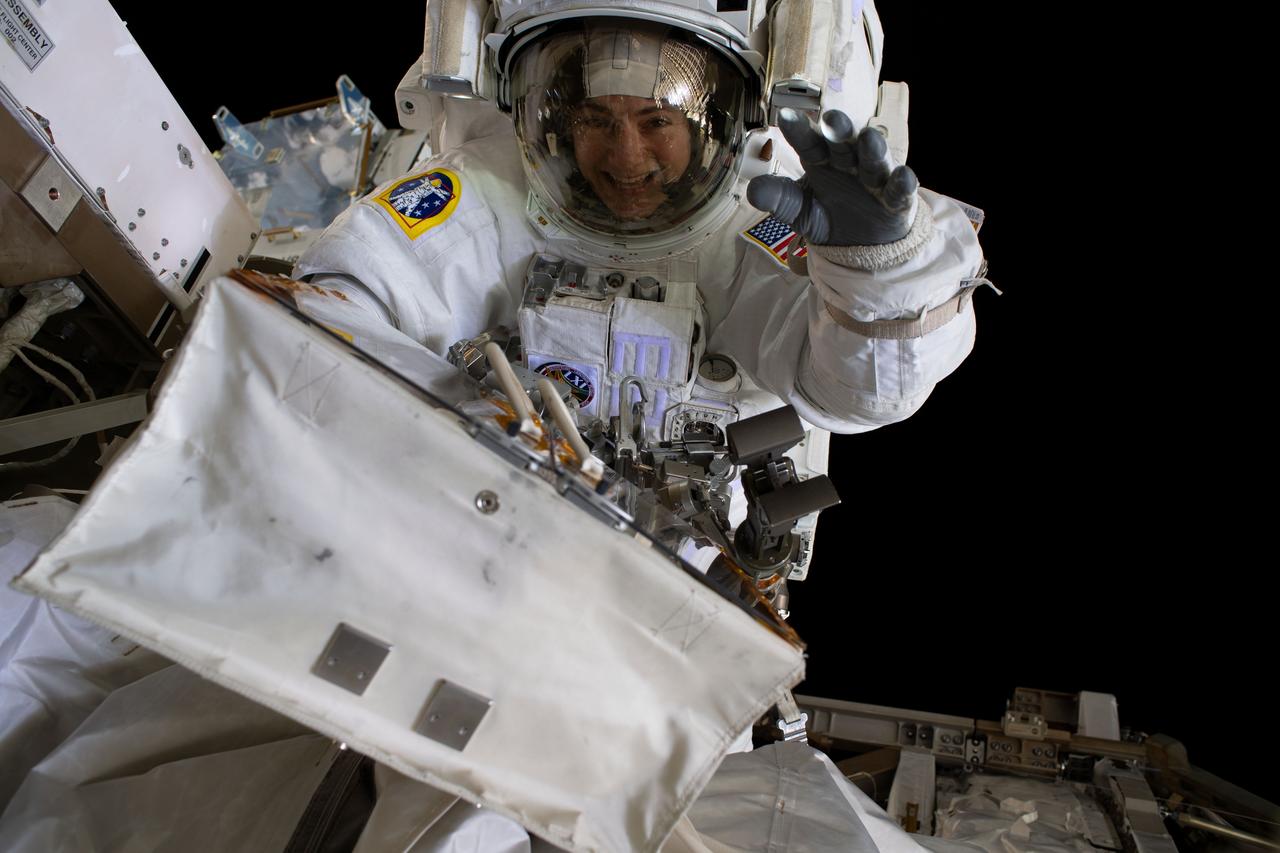 iss061e011841 (Oct. 18, 2019) --- NASA astronaut Jessica Meir waves at the camera during a spacewalk with fellow NASA astronaut Christina Koch (out of frame). They ventured into the vacuum of space for seven hours and 17 minutes to swap a failed battery charge-discharge unit (BCDU) with a spare during the first all-woman spacewalk. The BCDU regulates the charge to the batteries that collect and distribute solar power to the orbiting lab’s systems.